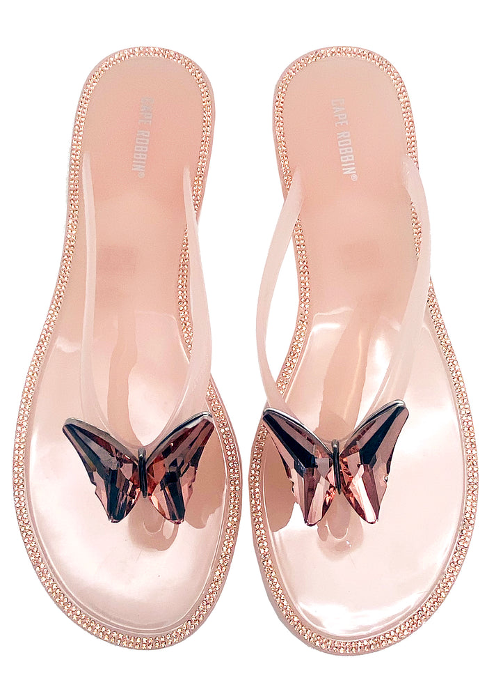 Cape Robbin Blushing Butterfly Jelly Sandals in blush pink PVC, featuring a slip-on thong profile with a sparkling jeweled butterfly accent on the upper strap.