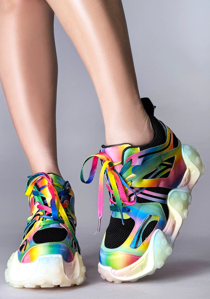 On-foot styling view from behind of Anthony Wang CARAMBOLA 03 Virtual Vibrance platform sneakers highlighting the neon pink, green, and blue wavy tentacle sole design elements