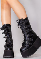 Demonia DAMNED 225 Dark Soul Black Platform Boots in black vegan leather with cone studded buckle straps worn by model — front view
