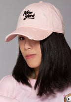 American Needle New York Shred Slouch Raglan Hat in baby pink with embroidered New York logo and distressed detail on cotton twill festival baseball cap — model front view