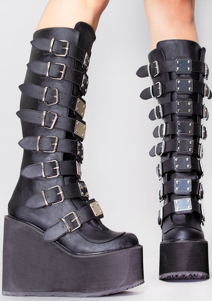Demonia SWING 815 Beautiful Destruction Black Platform Boots in black vegan PU leather with silver plate buckle detail worn by model — side view