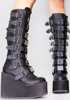 Demonia SWING 815 Beautiful Destruction Black Platform Boots in black vegan PU leather with silver plate buckle detail worn by model — side view