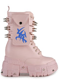 Side studio profile of Anthony Wang X WTF CV Chem Baby Metal Pink platform boots showing the pastel pink faux leather upper, utility side pocket with blue tribal symbol graphic, and spiked chunky platform soles